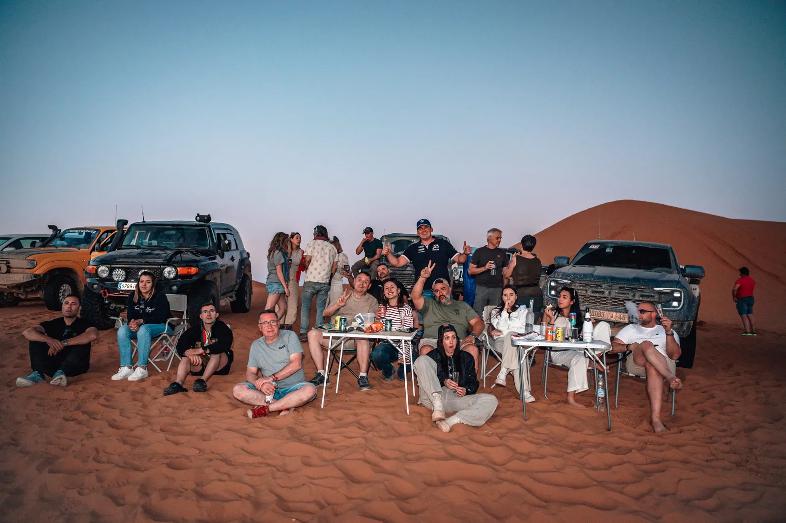 Grupo de viajeros DUNARX posando junto a sus 4x4 en una duna del Sáhara en Marruecos